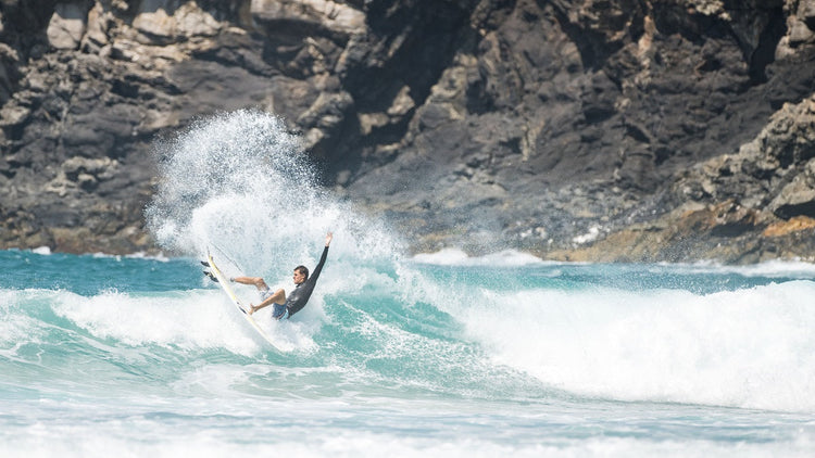 Surfer smacking the lip on a thruster fin set up.