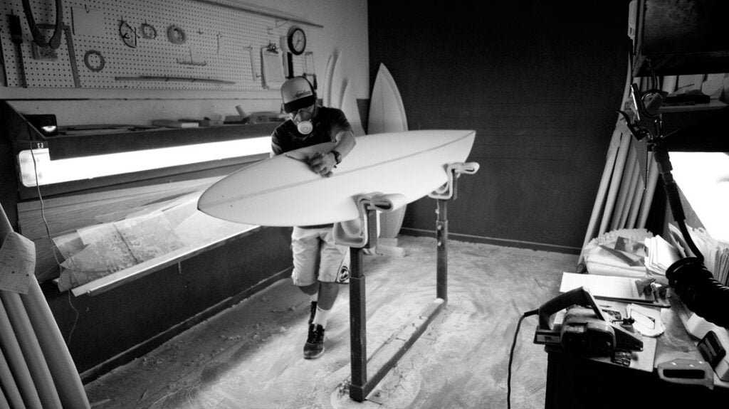 Eric Arakawa hand shaping a surfboard in his shop located on the North Shore of Oahu.