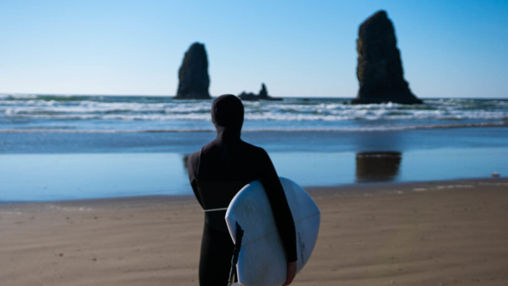 Surfer looking at at the surf while wearing the Sisstrevolution Women's Seven Seas wetsuit.